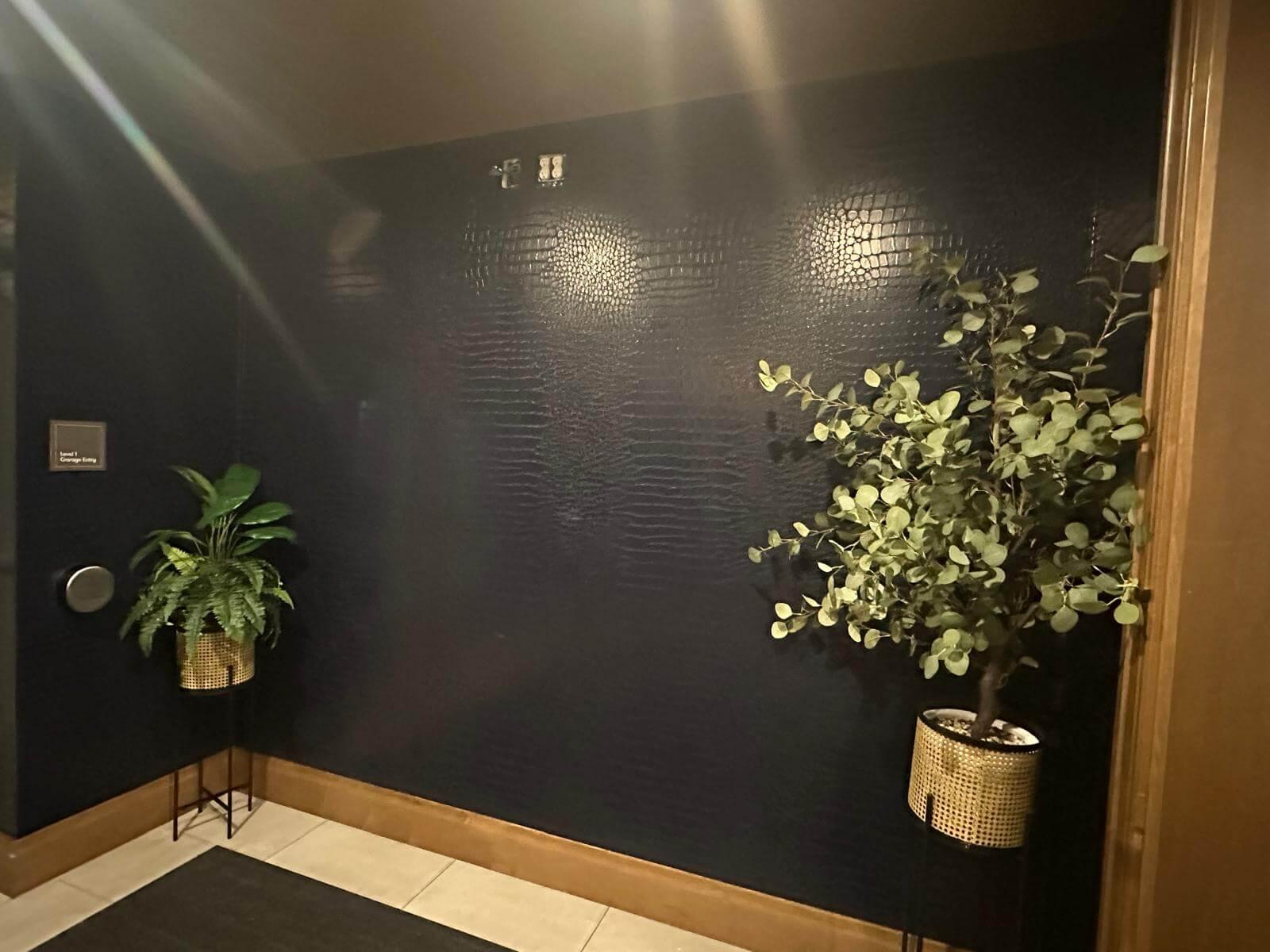 Navy blue wallpaper with alligator or snake texture-pattern on a wall.