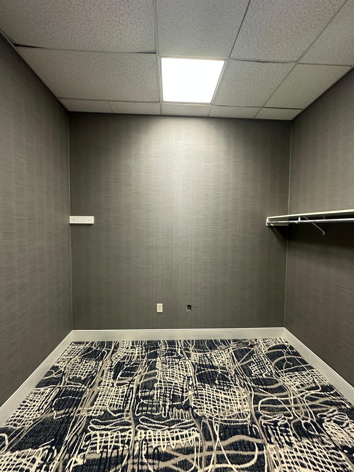 Square room with minimalist gray wallpaper.