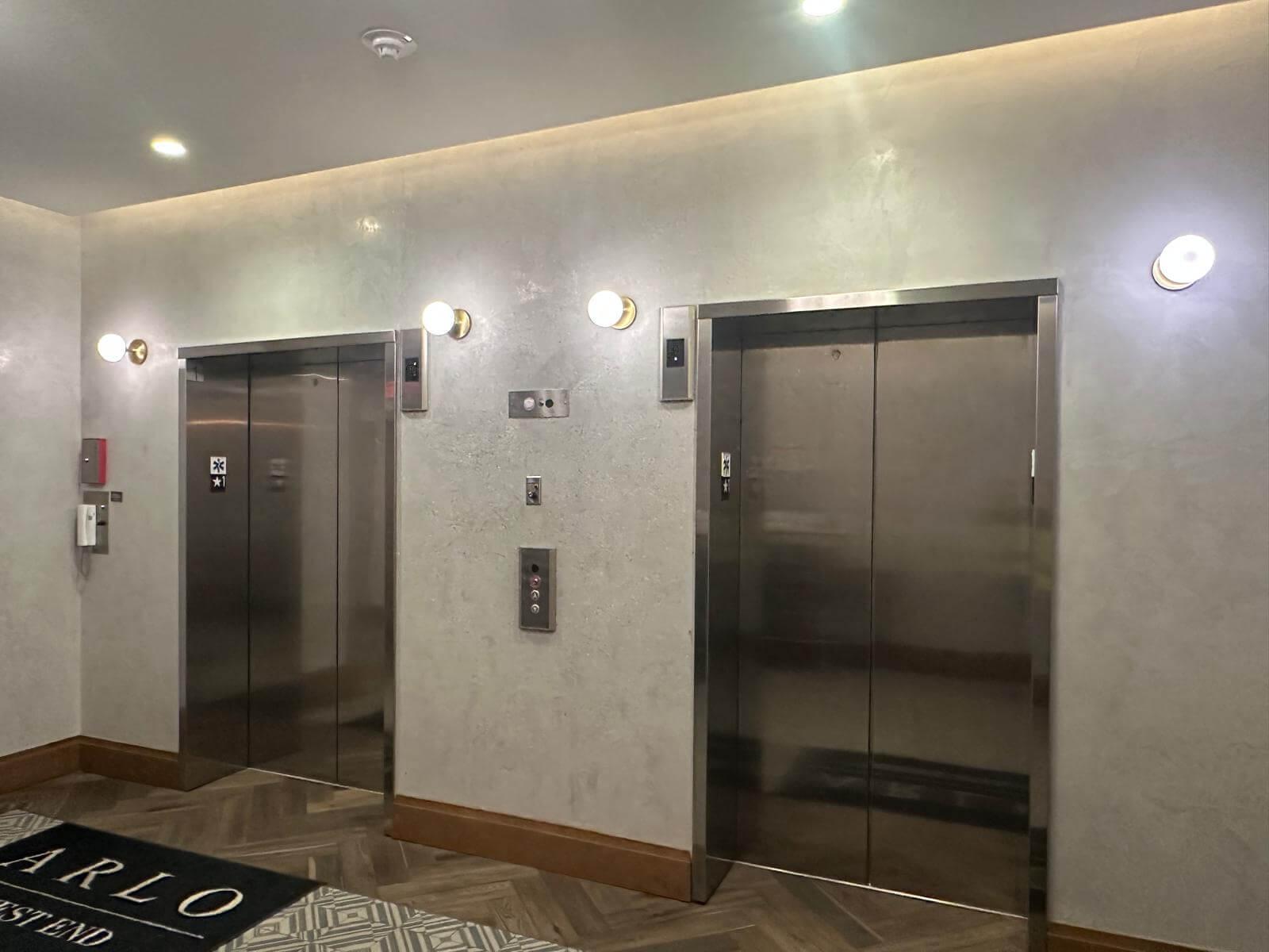 Elevator lobby with a minimalist beige wash wallpaper installed on the wall.