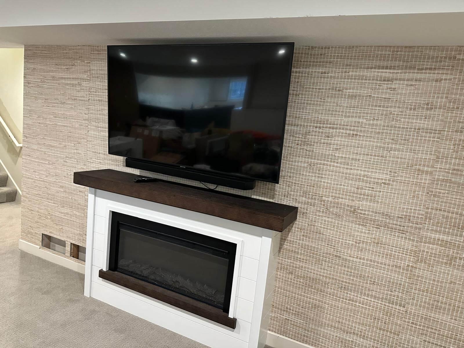 TV and fireplace with wallpaper on the wall behind.